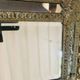 Small mirror with repoussé brass frame.