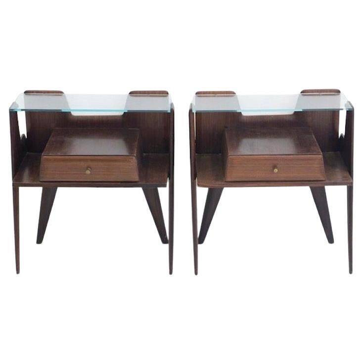 Pair of modernist Italian bedside tables in wood with a glass top.