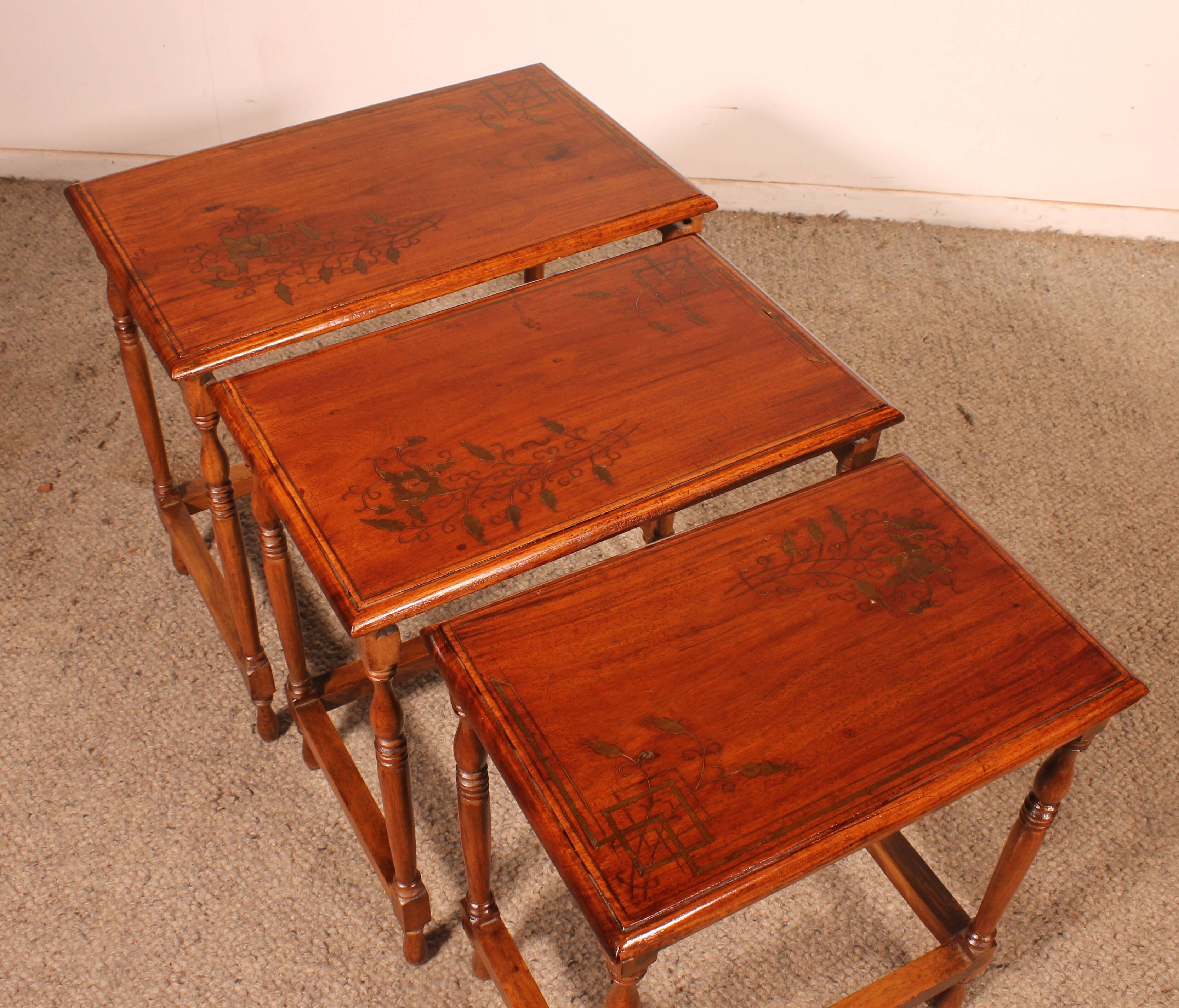Nested tables in satin wood with brass inlays.