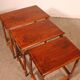 Nested tables in satin wood with brass inlays.