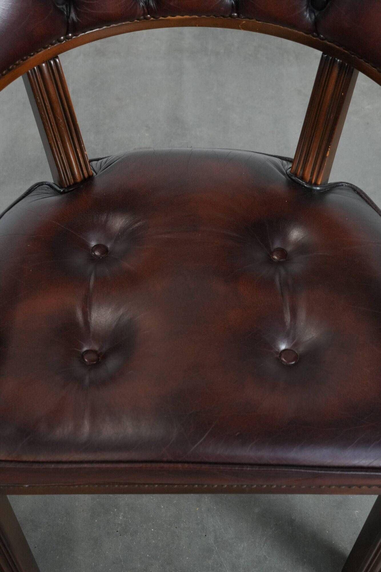 Set of two brown leather Chesterfield dining chairs in English style.