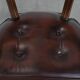 Set of two brown leather Chesterfield dining chairs in English style.