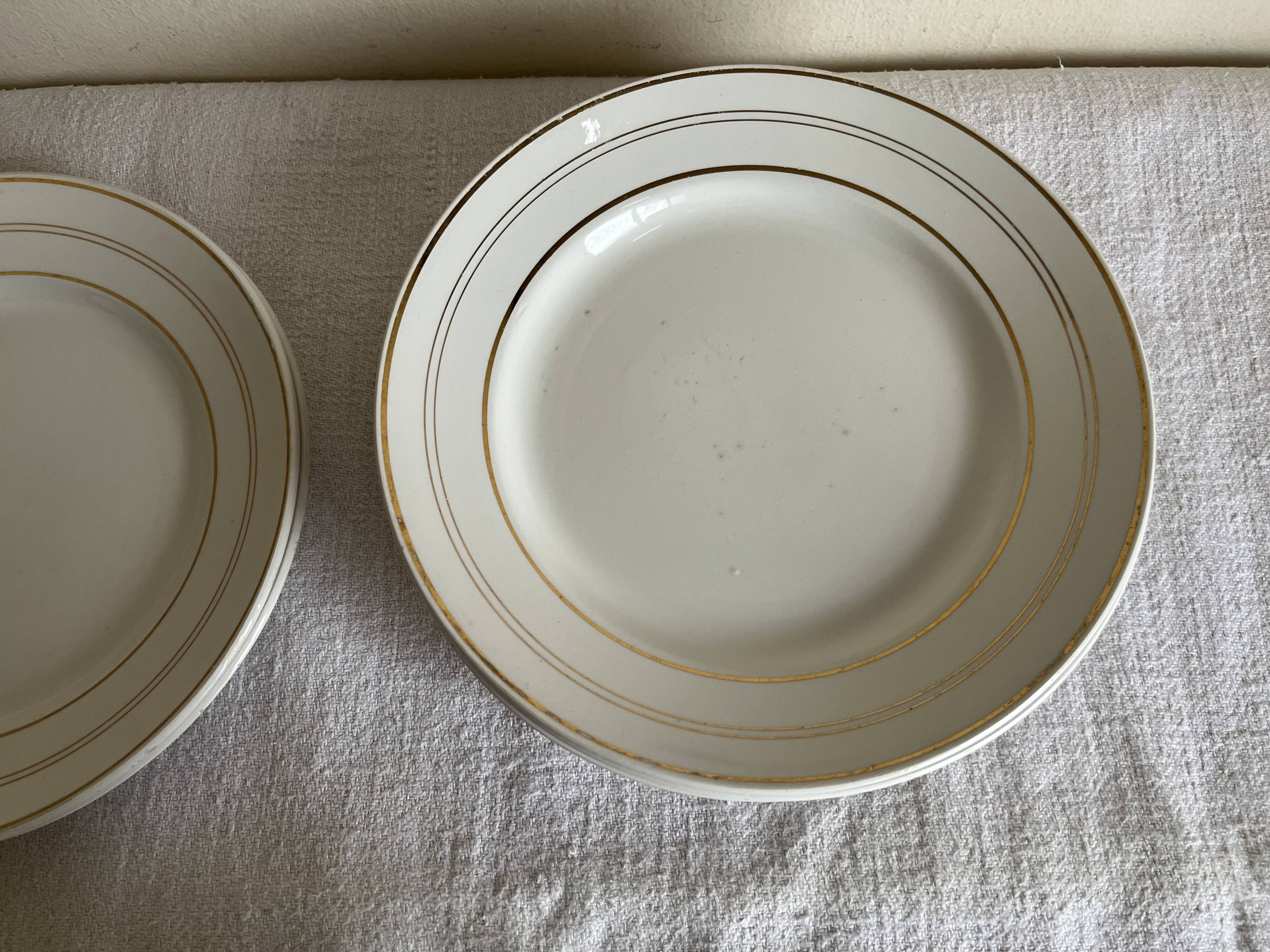 Set of 8 modernist flat plates in fine earthenware with pure gold trim, 1930.