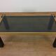 Italian coffee table from the 70s, smoked glass, black and gold lacquered wood.