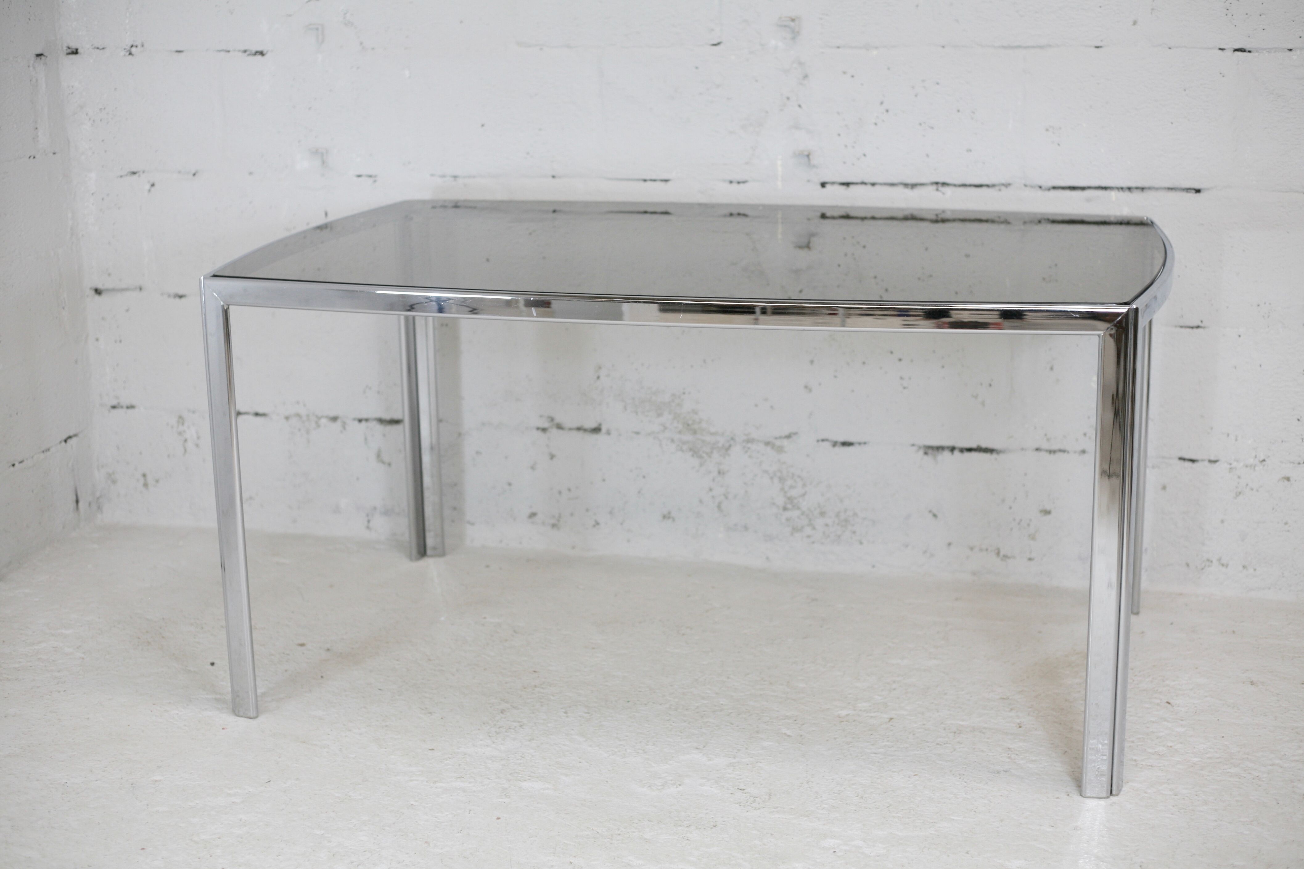 Living table. chrome metal, curved smoked glass slab, france, circa 1970.