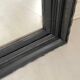 1950s mirror, matte black wood with a patina.