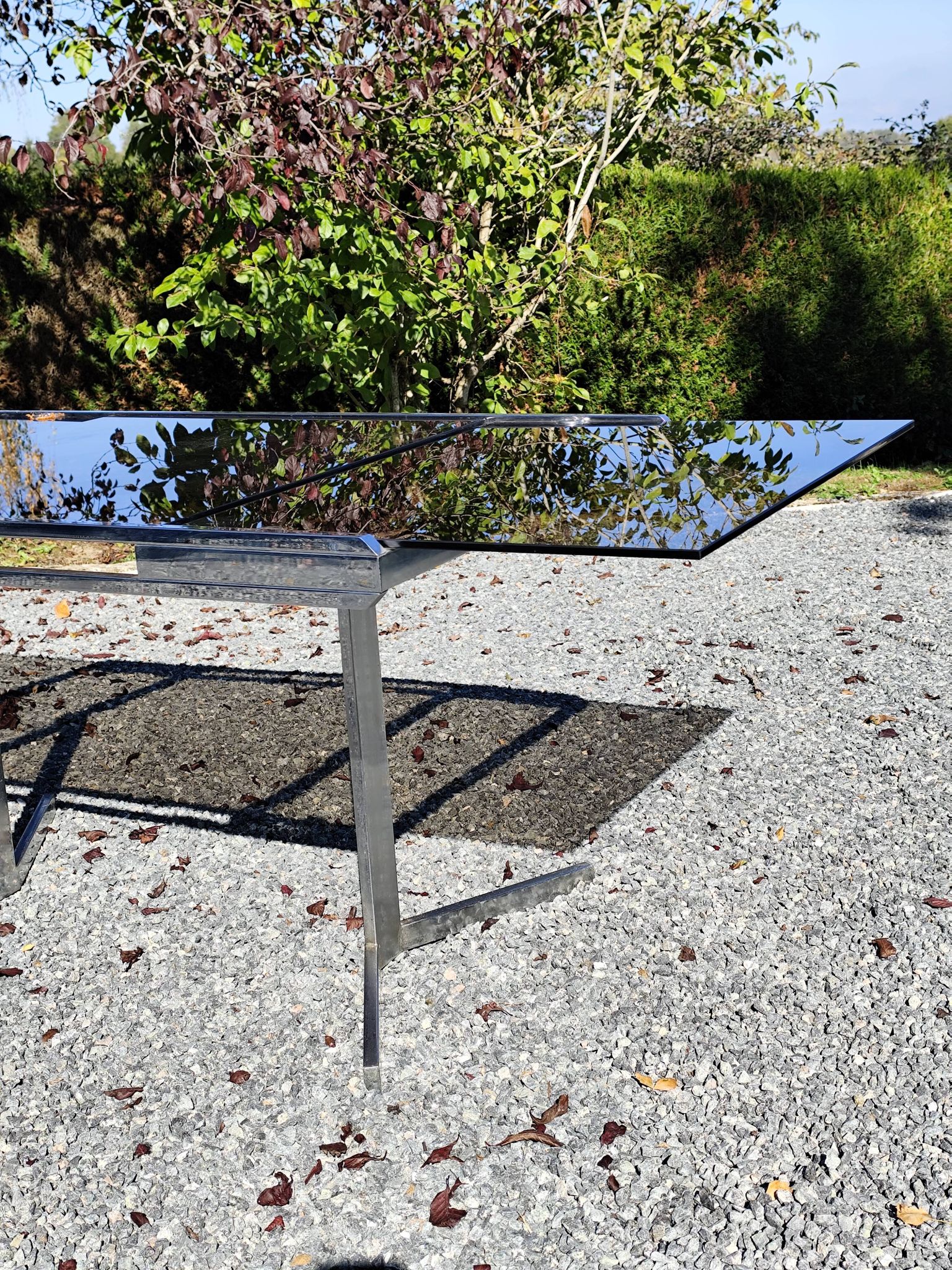 Table pietement chromé et verre fumé année 70 avec allonges