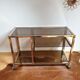 Service table with vintage brass wheels / smoked glass