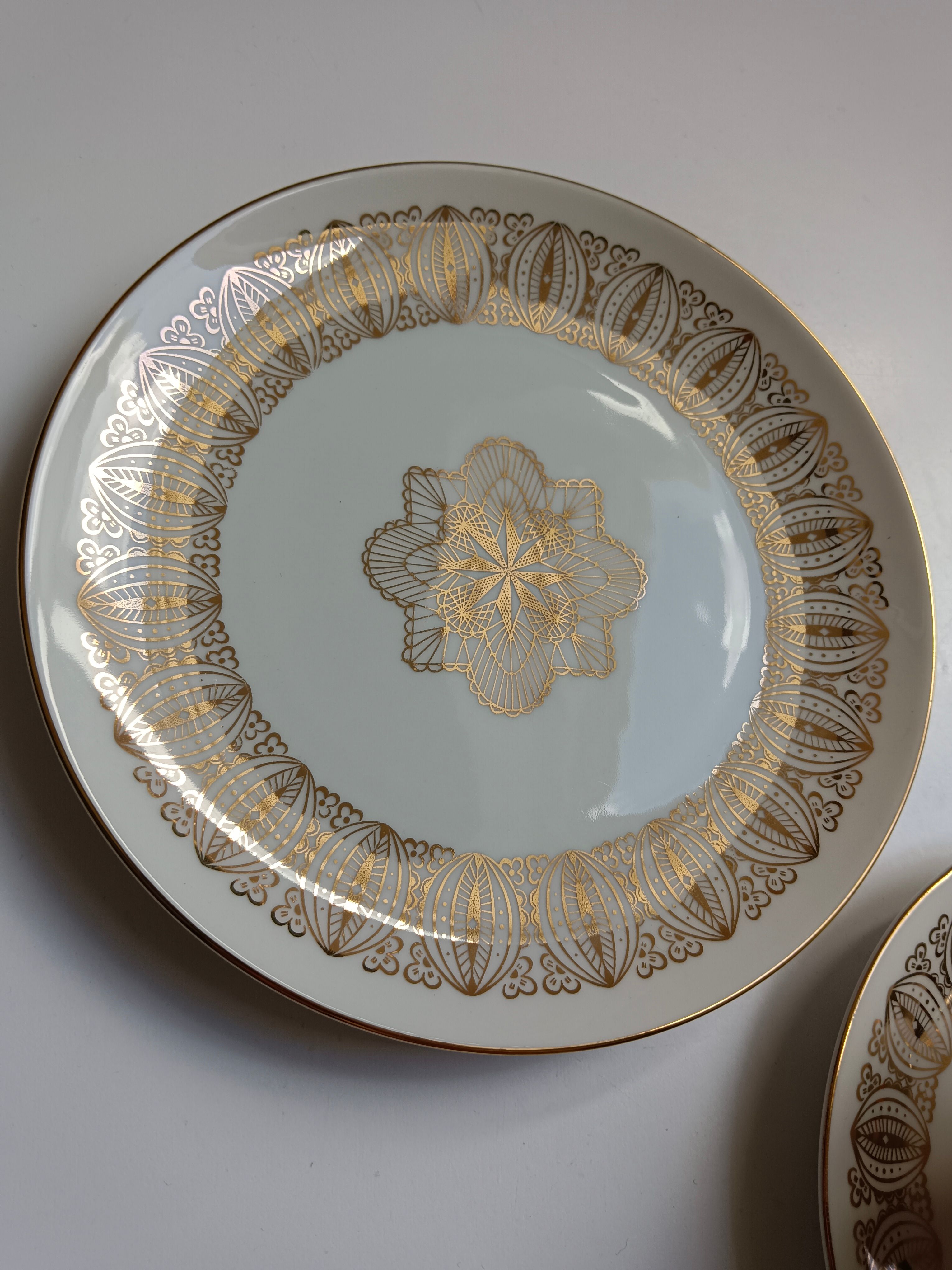 Solitaire tea cup, saucer, and dessert plate in white and gold.
