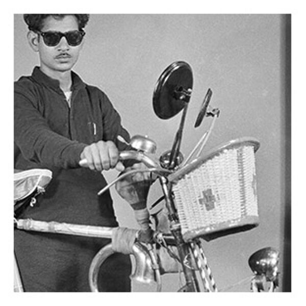 Photographie d'un Indien posant avec son vélo