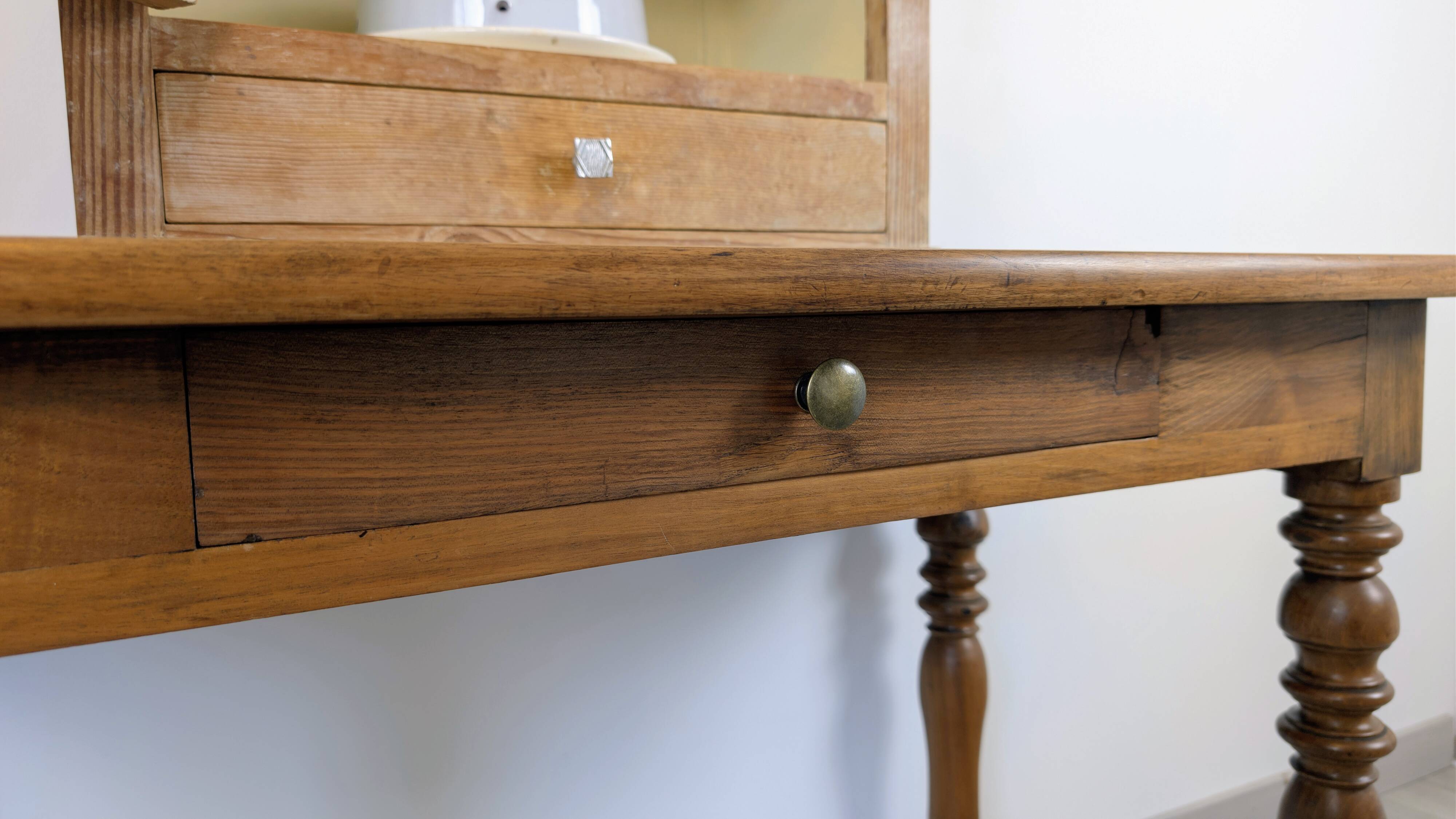 Antique writing table in the Napoleon III style with turned wooden legs.