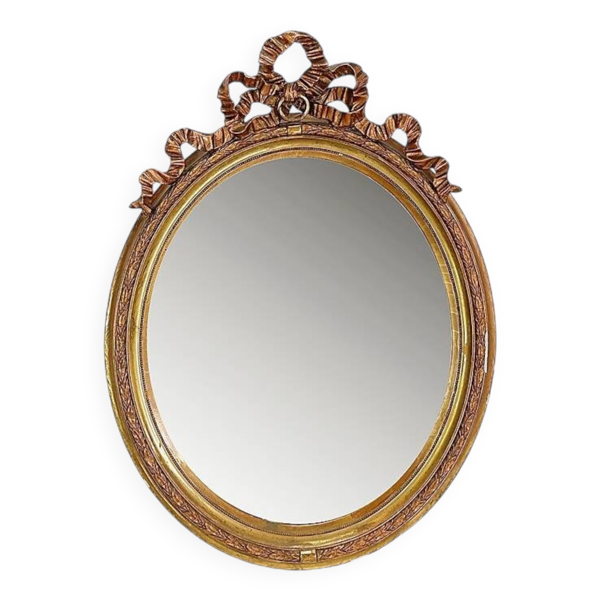 Wear consistent with age and use  Wood and gilded plaster ''Noeud d'Amour'' Oval mirror