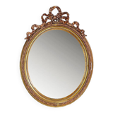 Wear consistent with age and use Wood and gilded plaster "Noeud d'Amour" Oval mirror