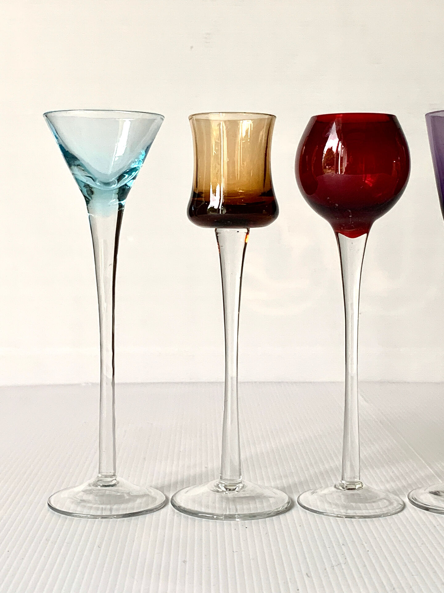 Cinq verres à liqueur colorés sur pied