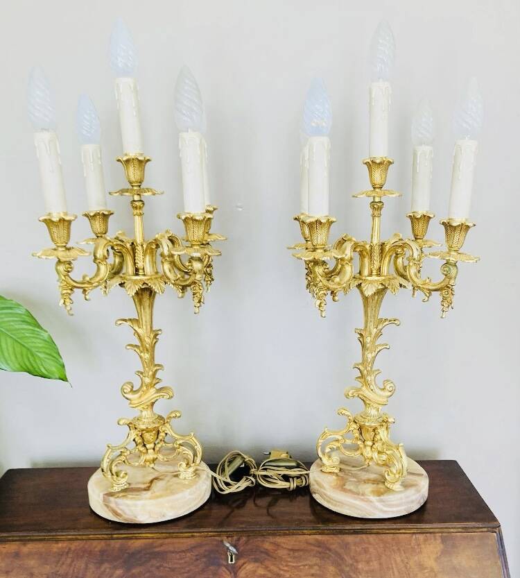 Massive gilded bronze chandeliers from the mid-20th century with marble bases.