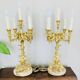 Massive gilded bronze chandeliers from the mid-20th century with marble bases.