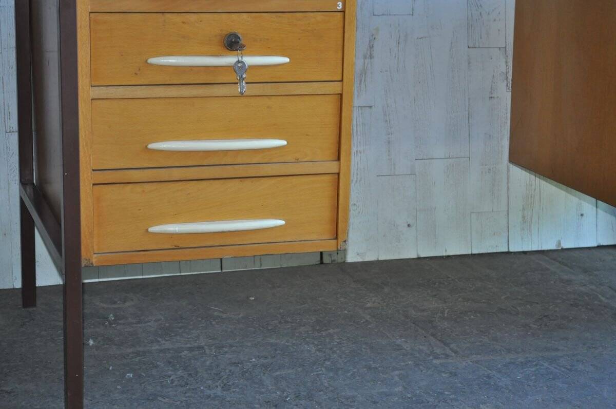 Mid-century Hungarian brown wooden desk with symmetrical drawers and white handles.