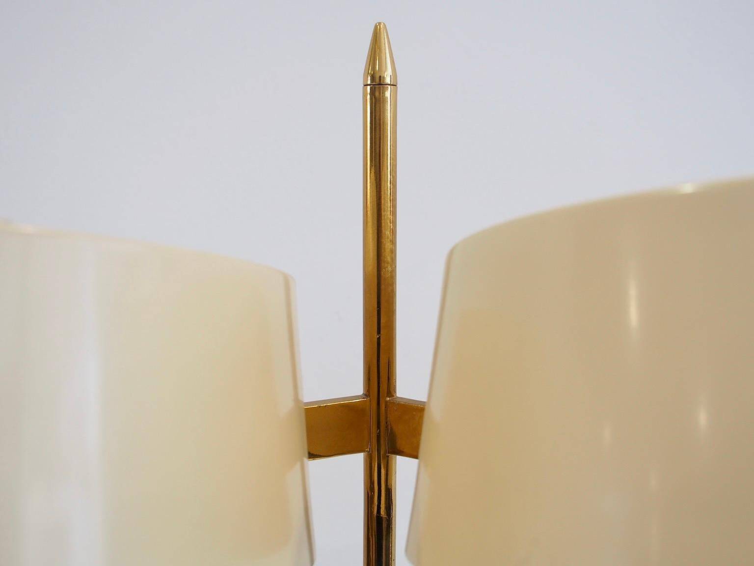 Brass and lacquered metal floor lamp with a wooden magazine shelf.