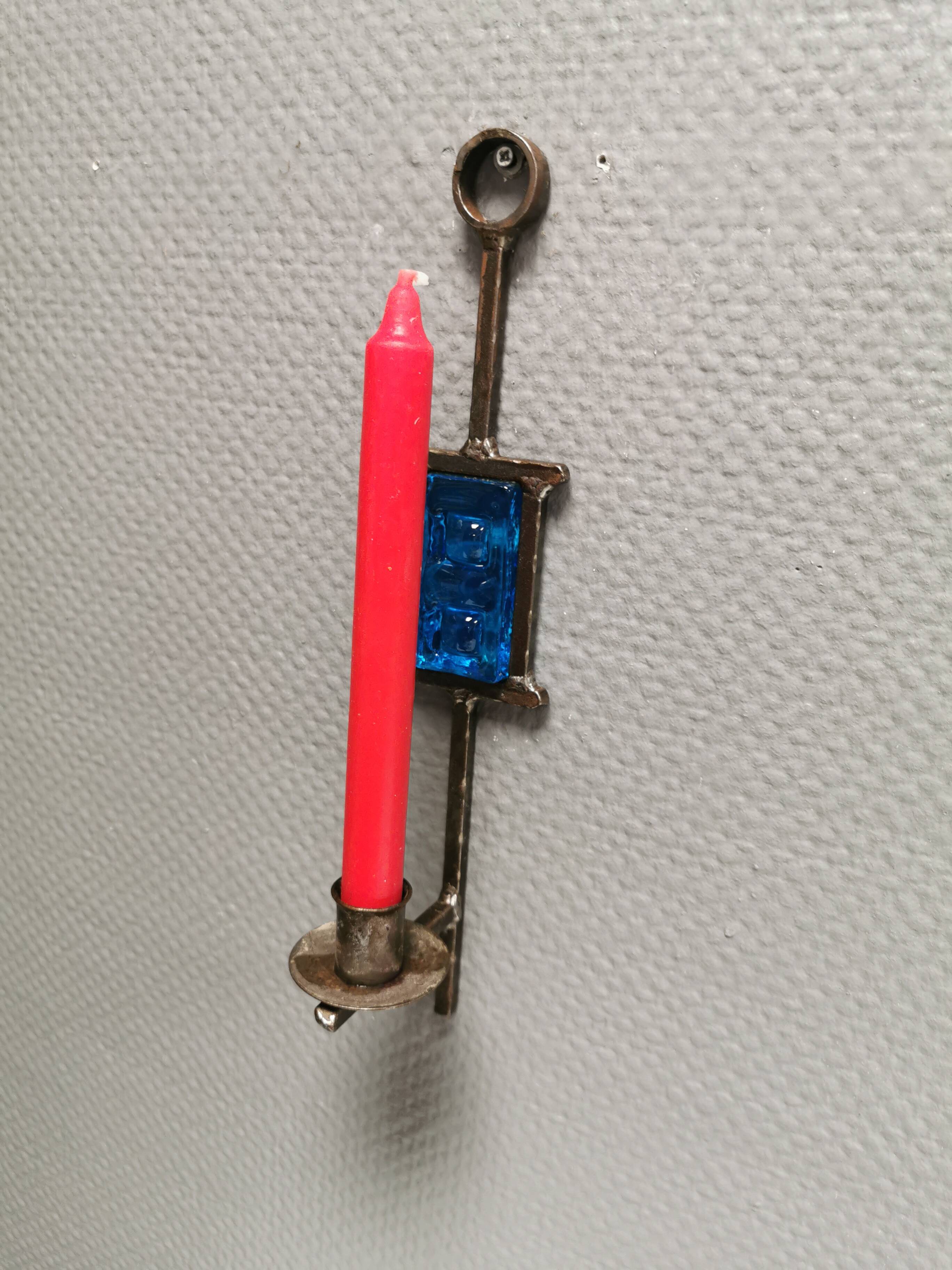 Wall-mounted candle holder in cast iron and hard pressed blue glass.