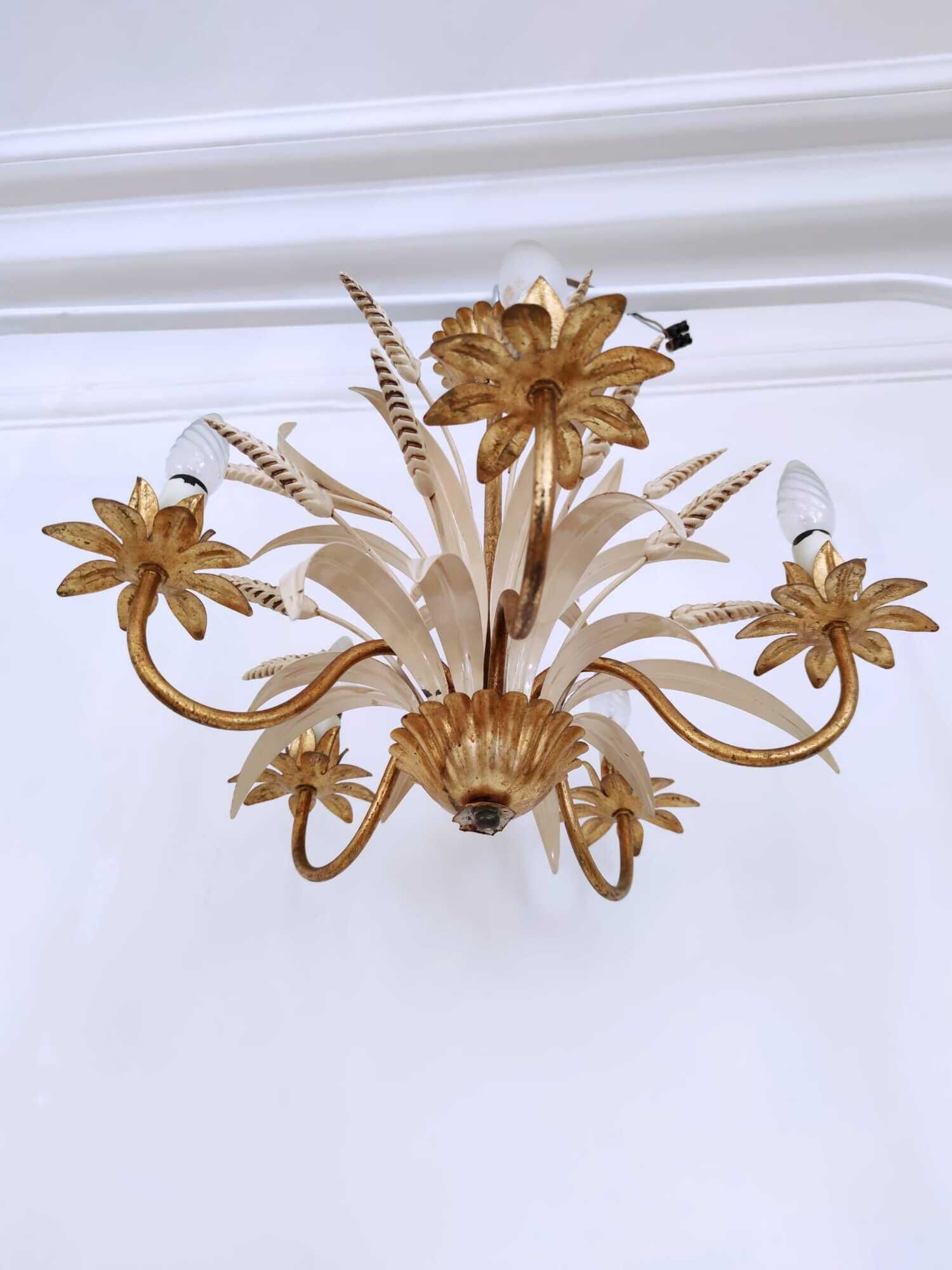 Vintage wrought iron chandelier decorated with golden and beige reeds