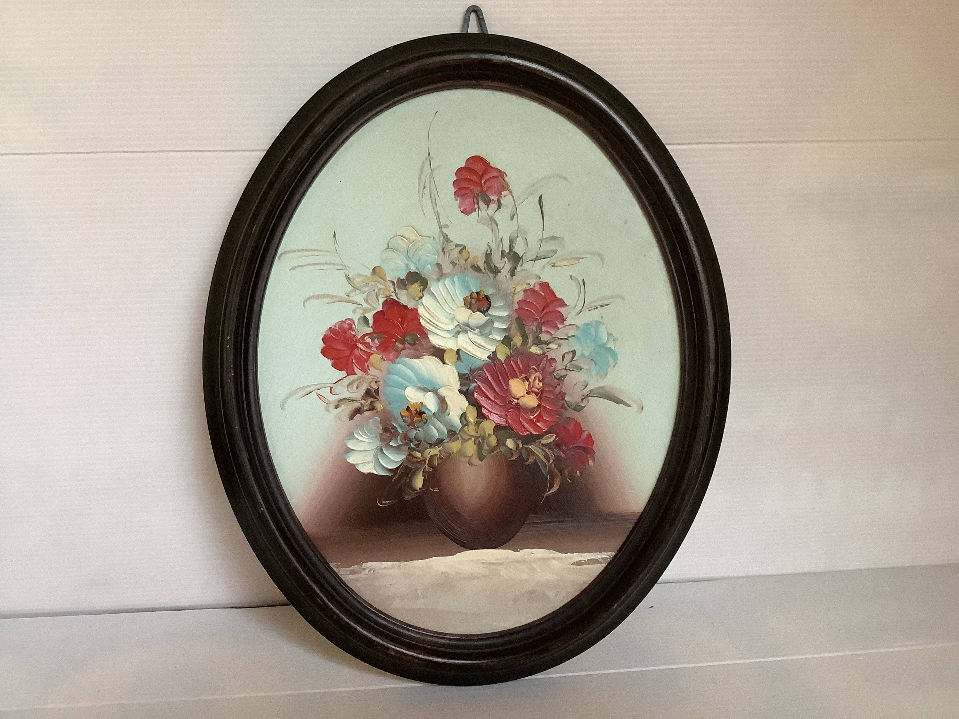 Oval painting of a bouquet of flowers, oil on panel.