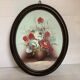 Oval painting of a bouquet of flowers, oil on panel.
