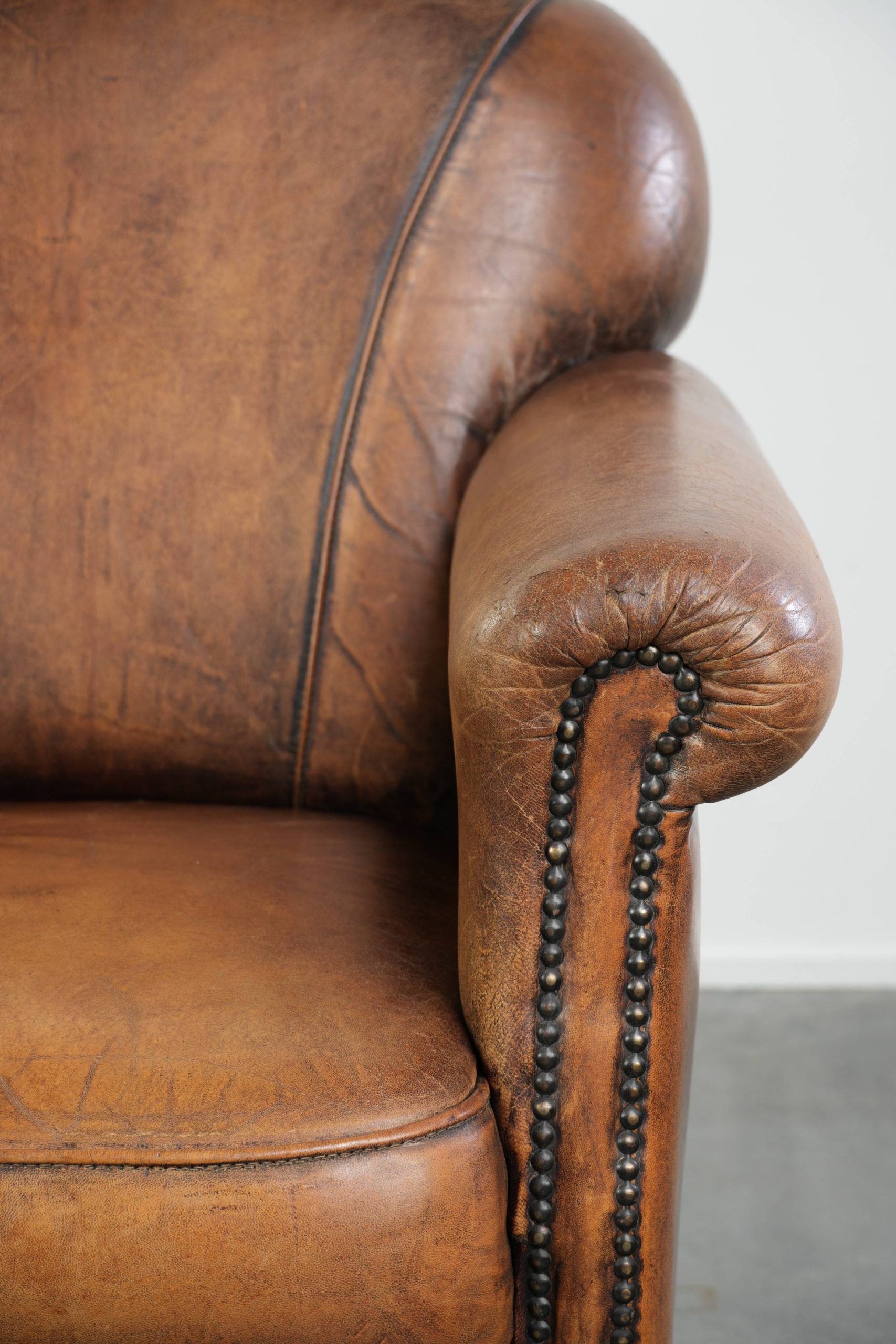 Comfortable characterful sheepskin armchair finished with decorative nails