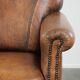 Comfortable characterful sheepskin armchair finished with decorative nails