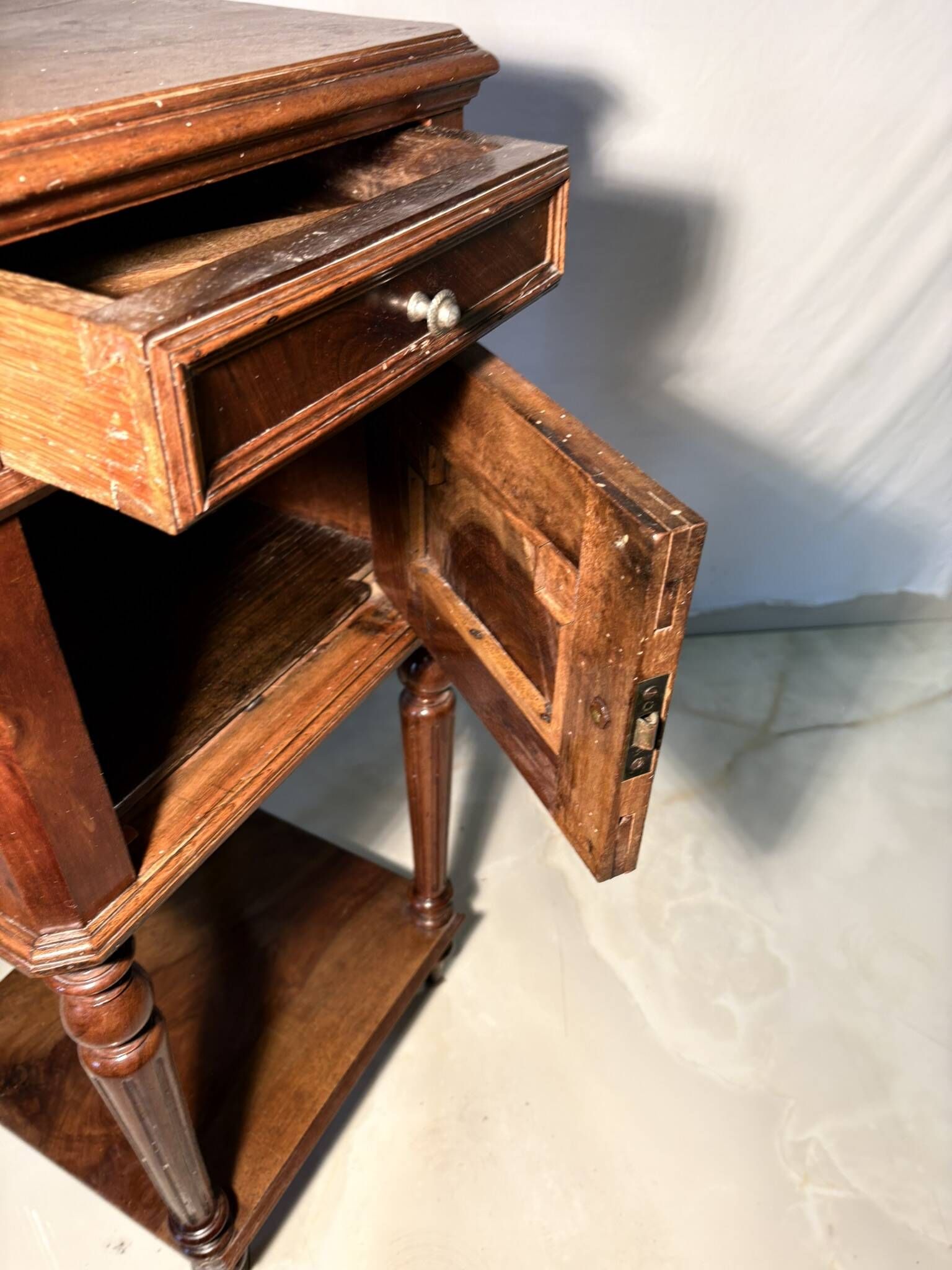 Antique wooden bedside table with turned legs.