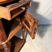 Antique wooden bedside table with turned legs.