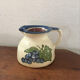 Terracotta jug with grape decoration.