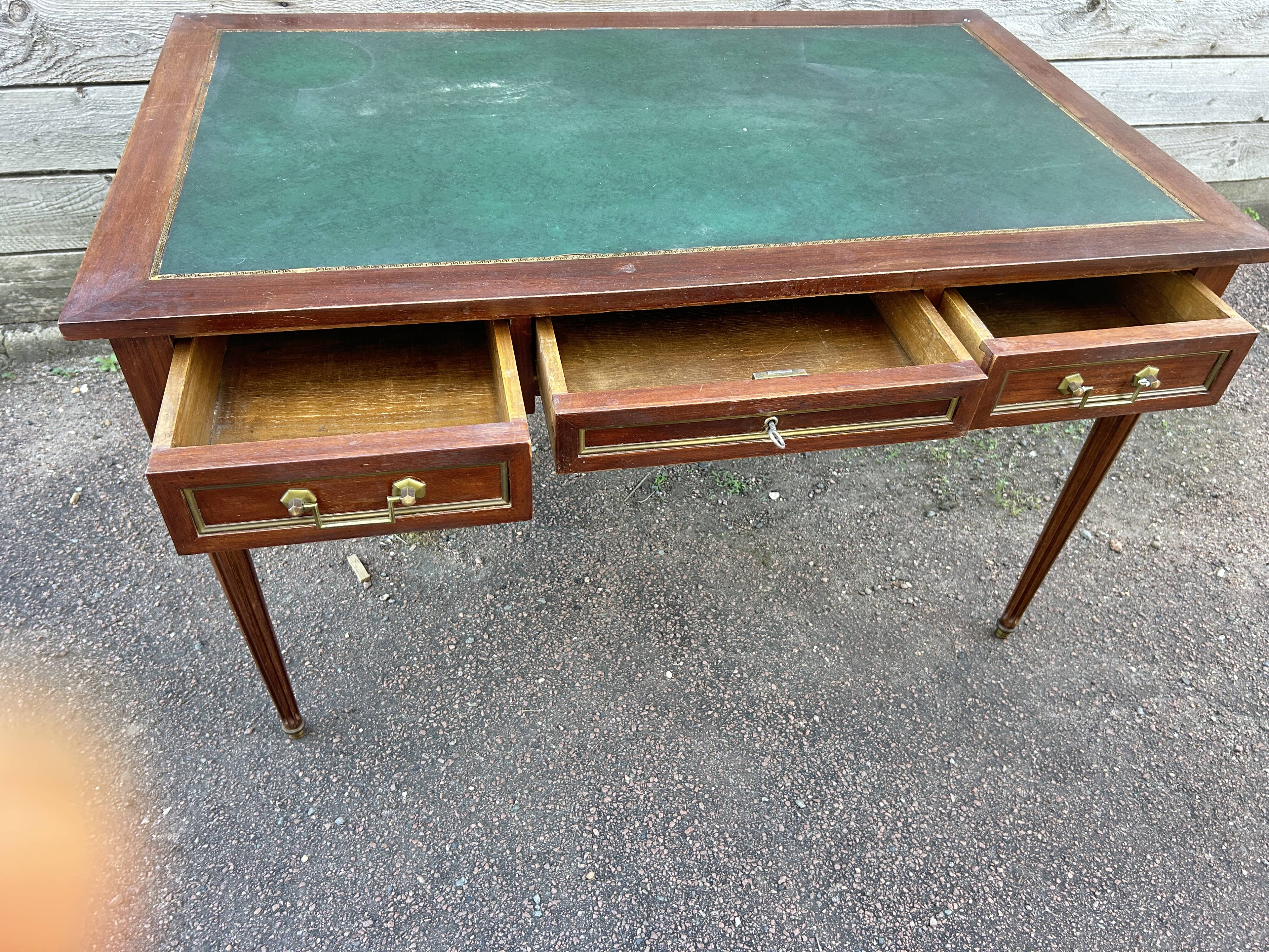 Louis XVI style desk in mahogany with a green leather top.