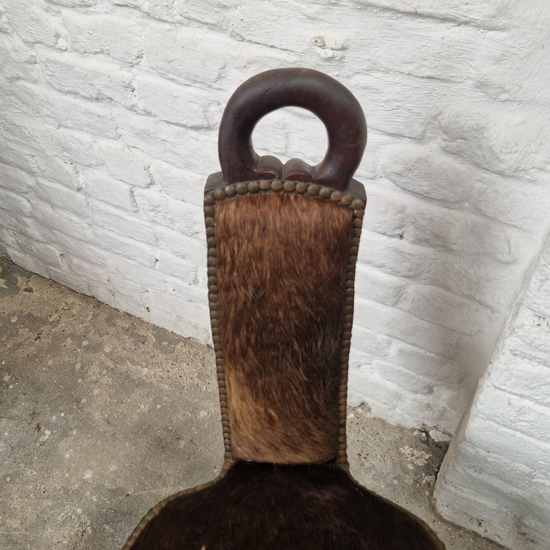 Antique tripod chair in solid wood and animal skin.