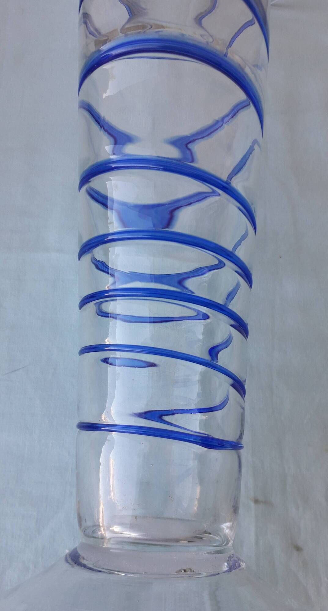 Glass vase on a pedestal with a blue trim.