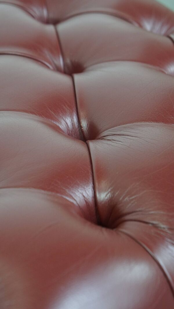 Pouf Chesterfield élégant rouge/marron en cuir de vachette, en très bon état.