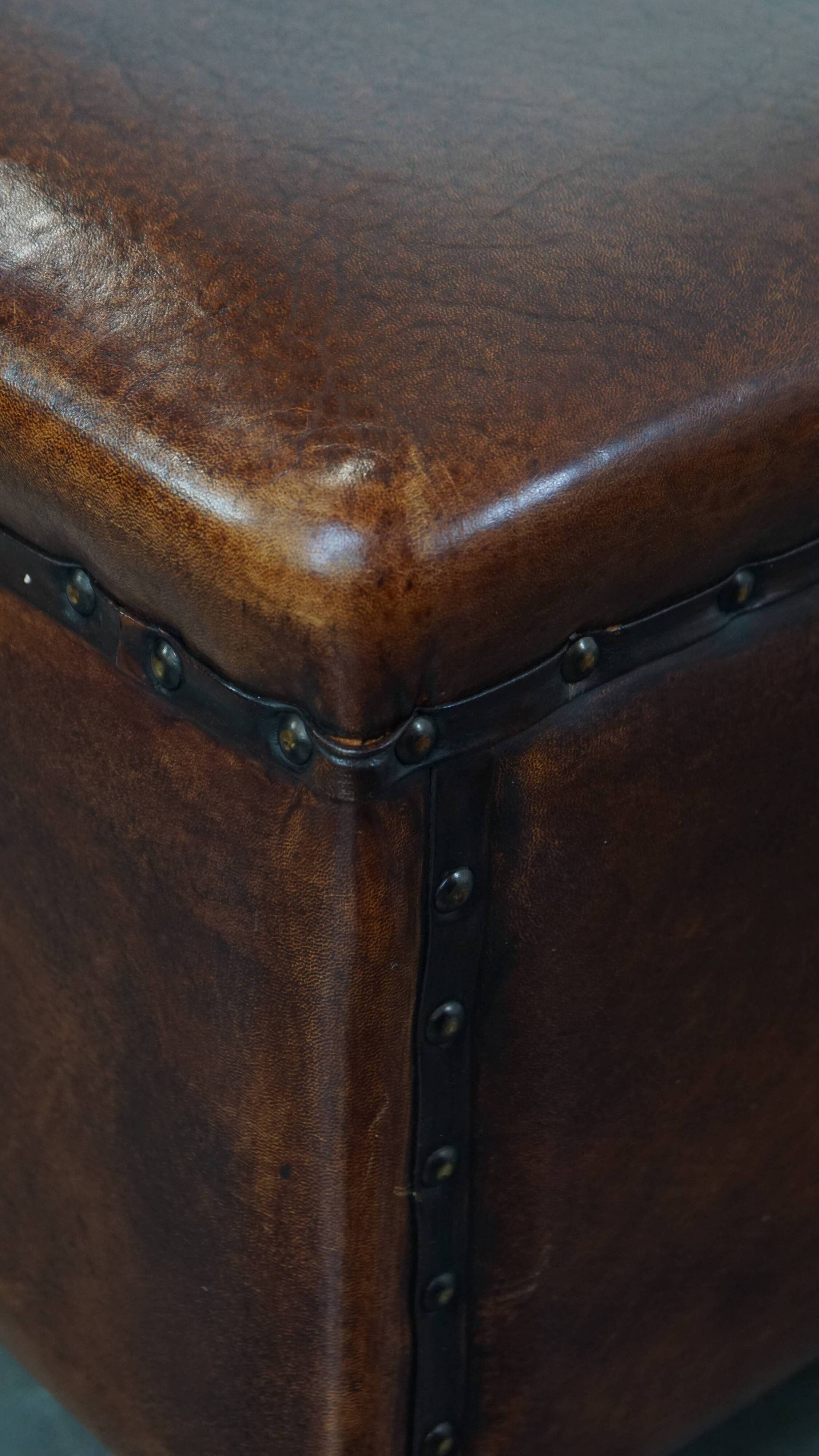 Cognac-colored sheepskin stool with decorative studs