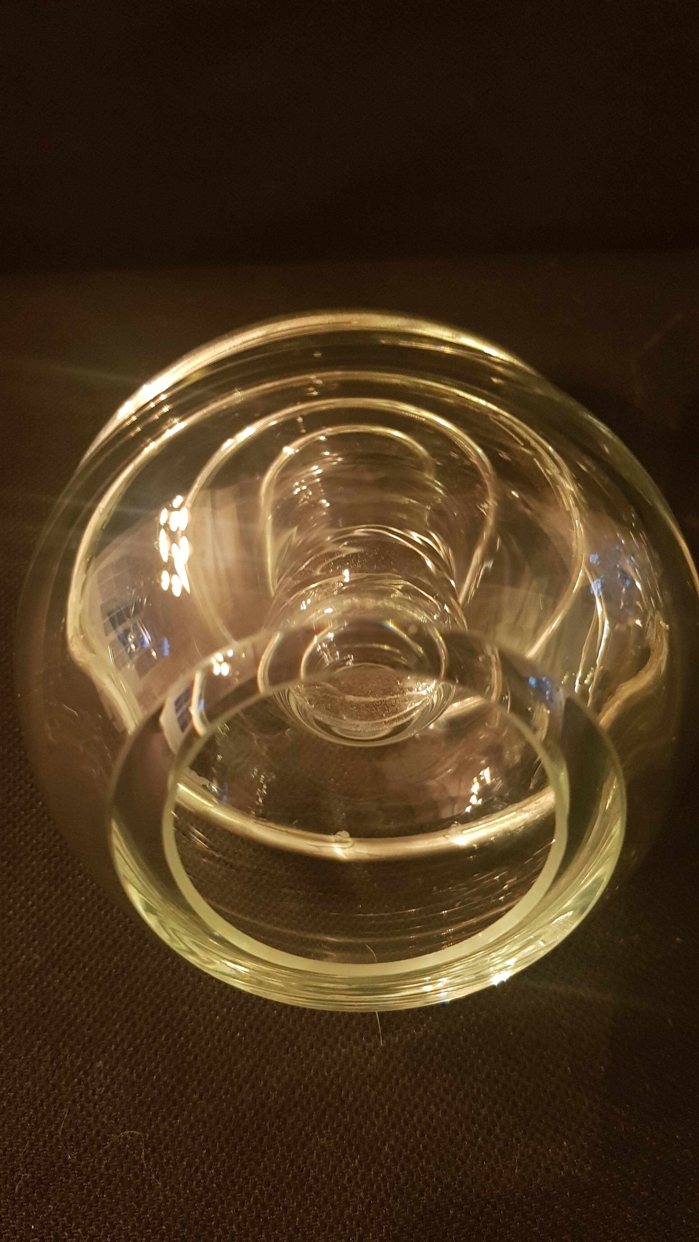 Round glass candle holder with silver-plated metal spiral.