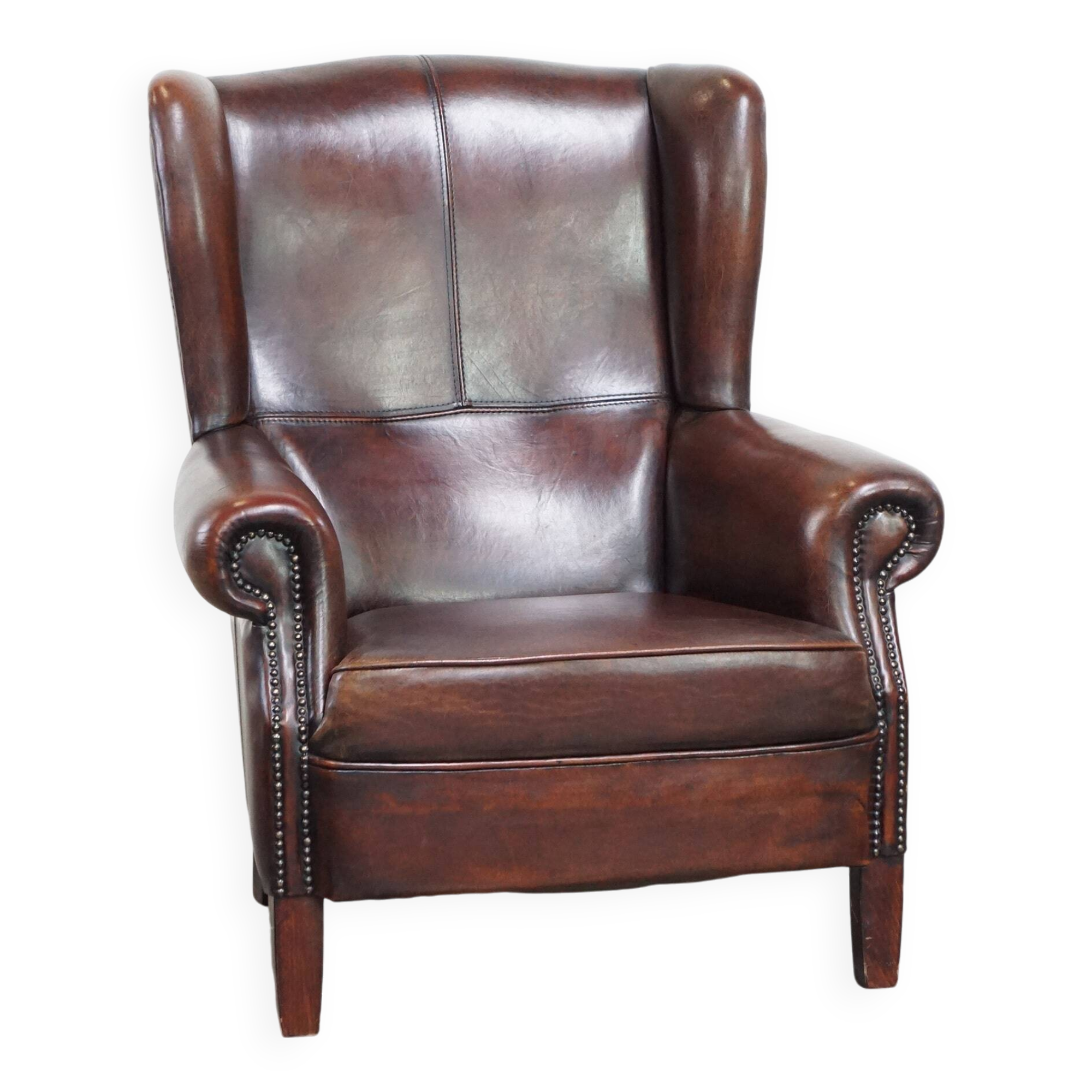 Fauteuil à oreilles confortable et bien entretenu en cuir de mouton