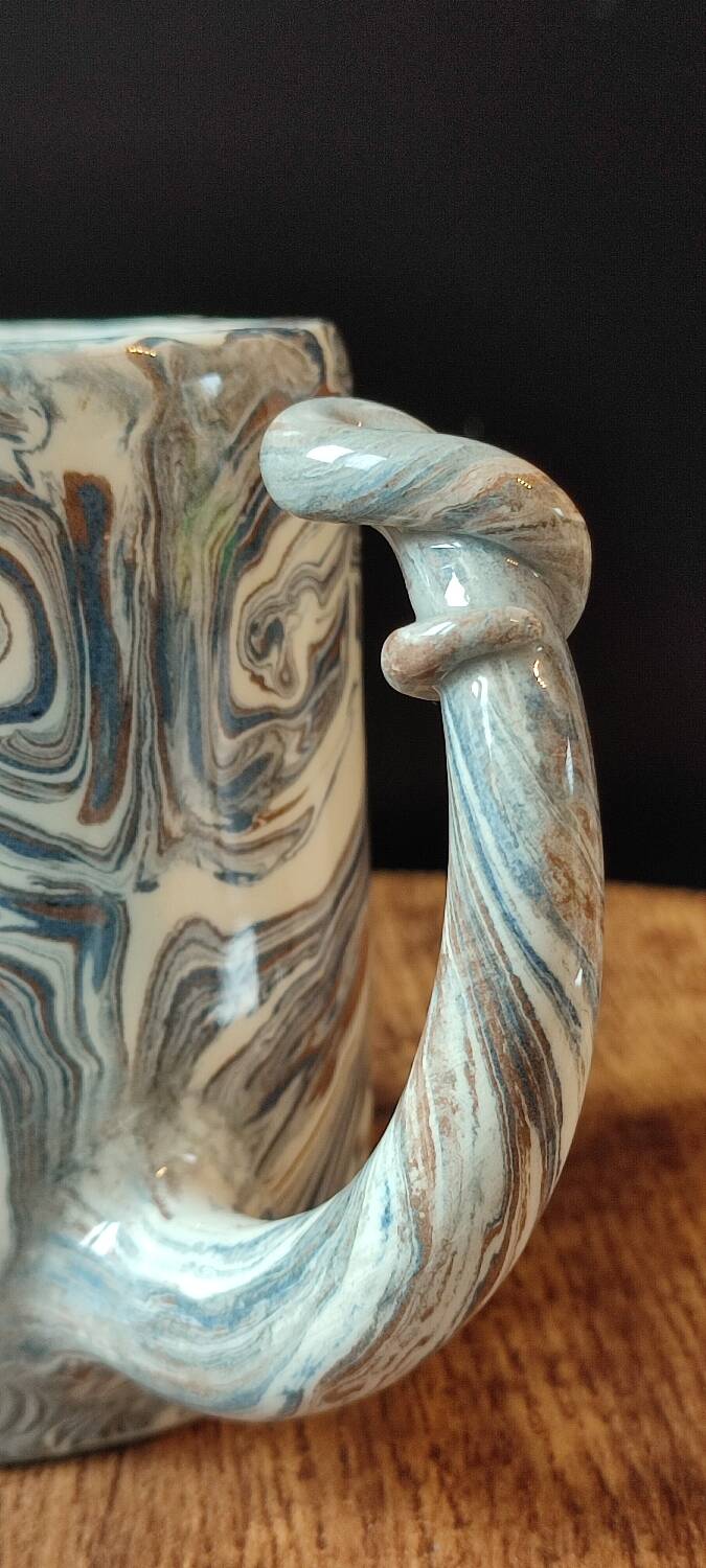 Handcrafted ceramic mug with marbled design, unique piece.