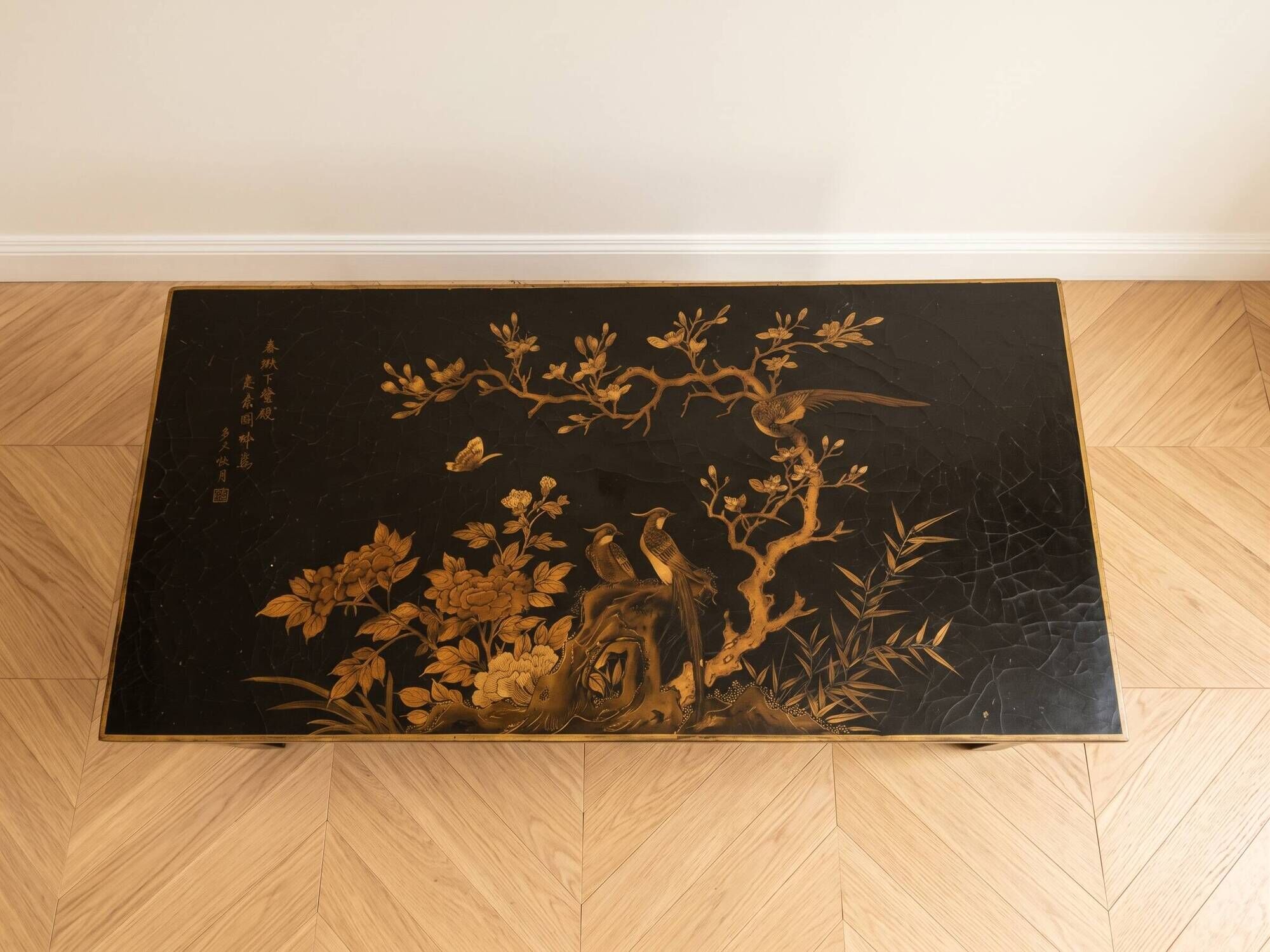 Antique Chinese coffee table in black and gold lacquered wood.