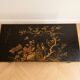 Antique Chinese coffee table in black and gold lacquered wood.