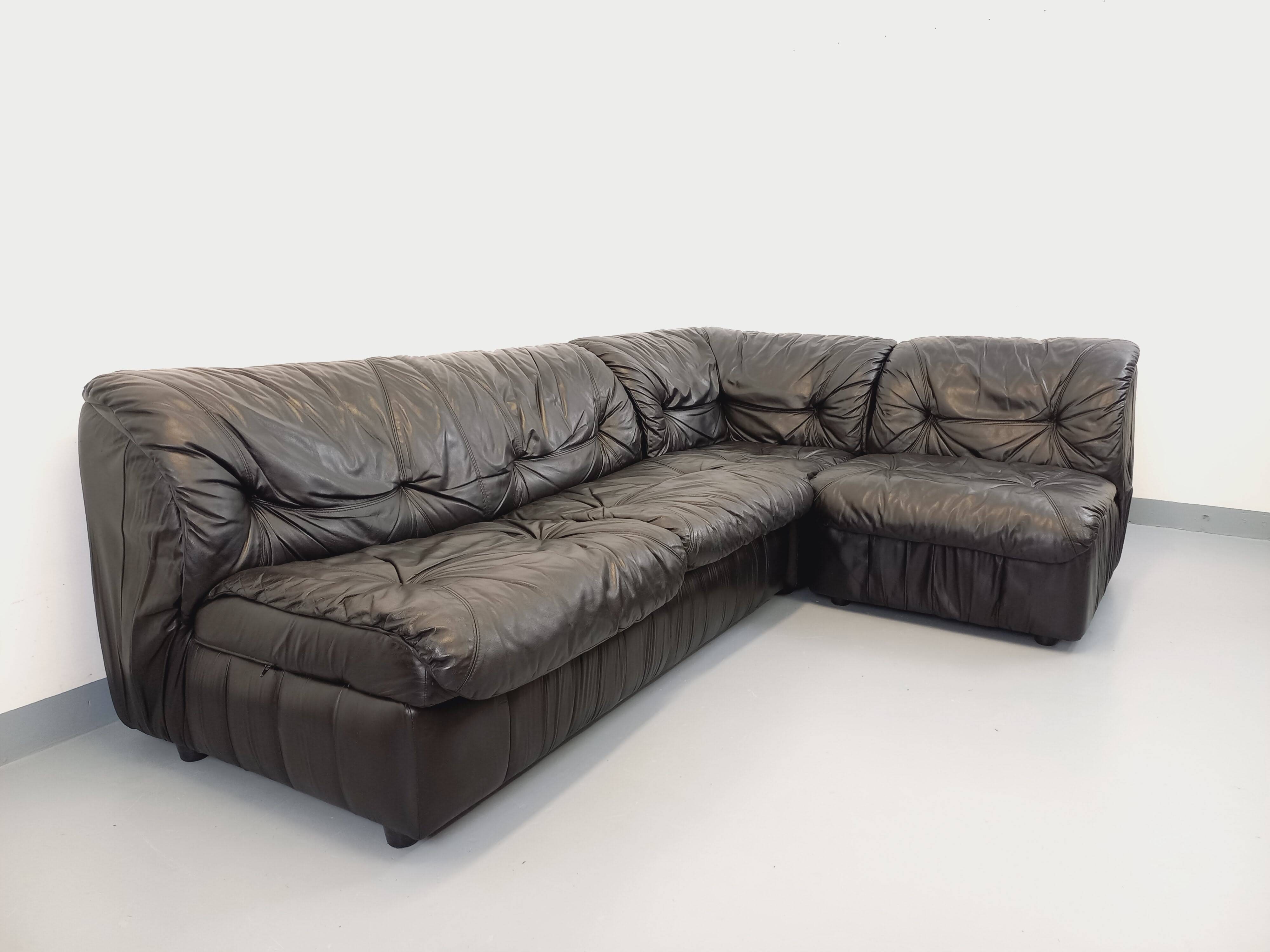 Vintage corner sofa composed of 3 modules in black leather with integrated bed.