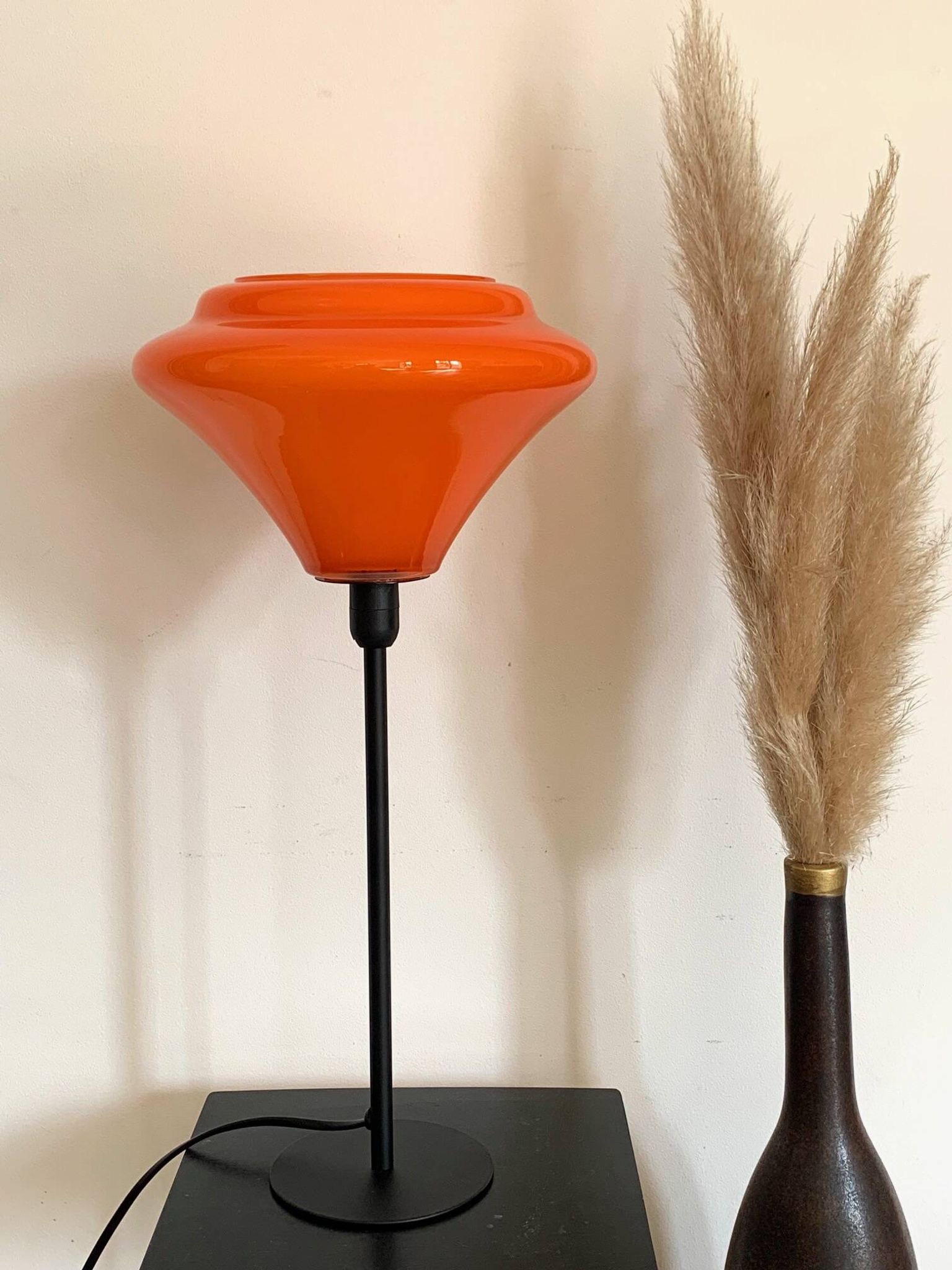 Table lamp with a vintage orange glass globe and a gold base