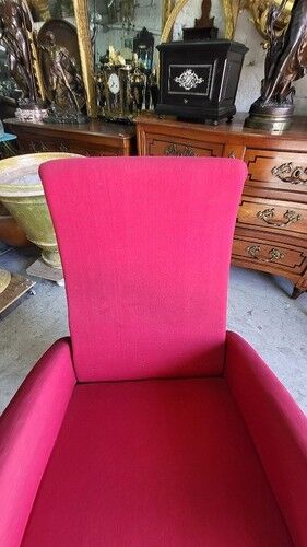 Old cinema chair with a red reclining seat.