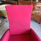 Old cinema chair with a red reclining seat.