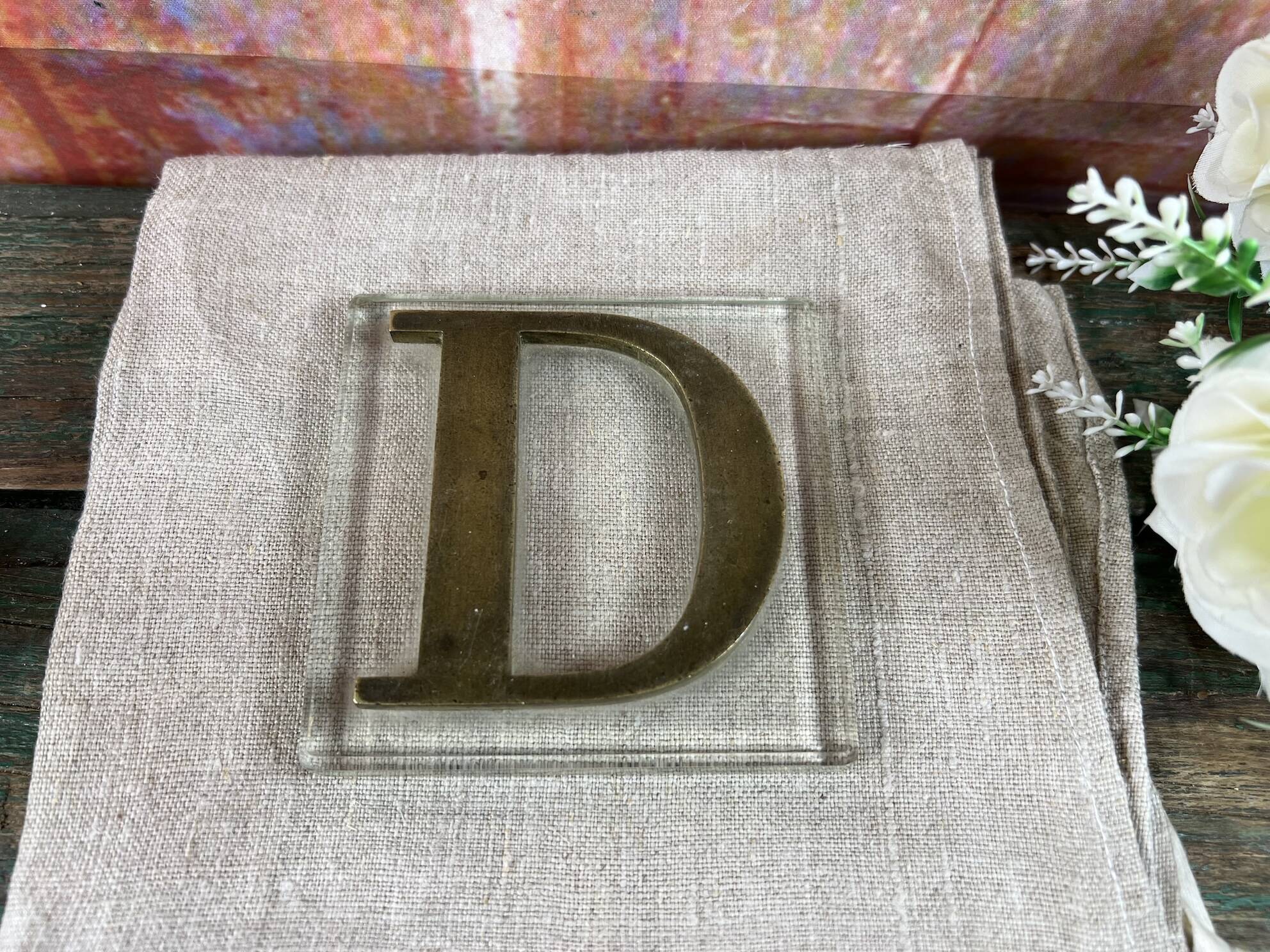 Metal letter D on glass plate