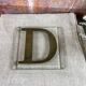 Metal letter D on glass plate