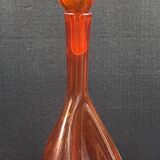 Orange bubbled glass bottle with curved body, circa 1970