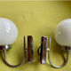 Pair of chrome metal wall lights with white glass globe.
