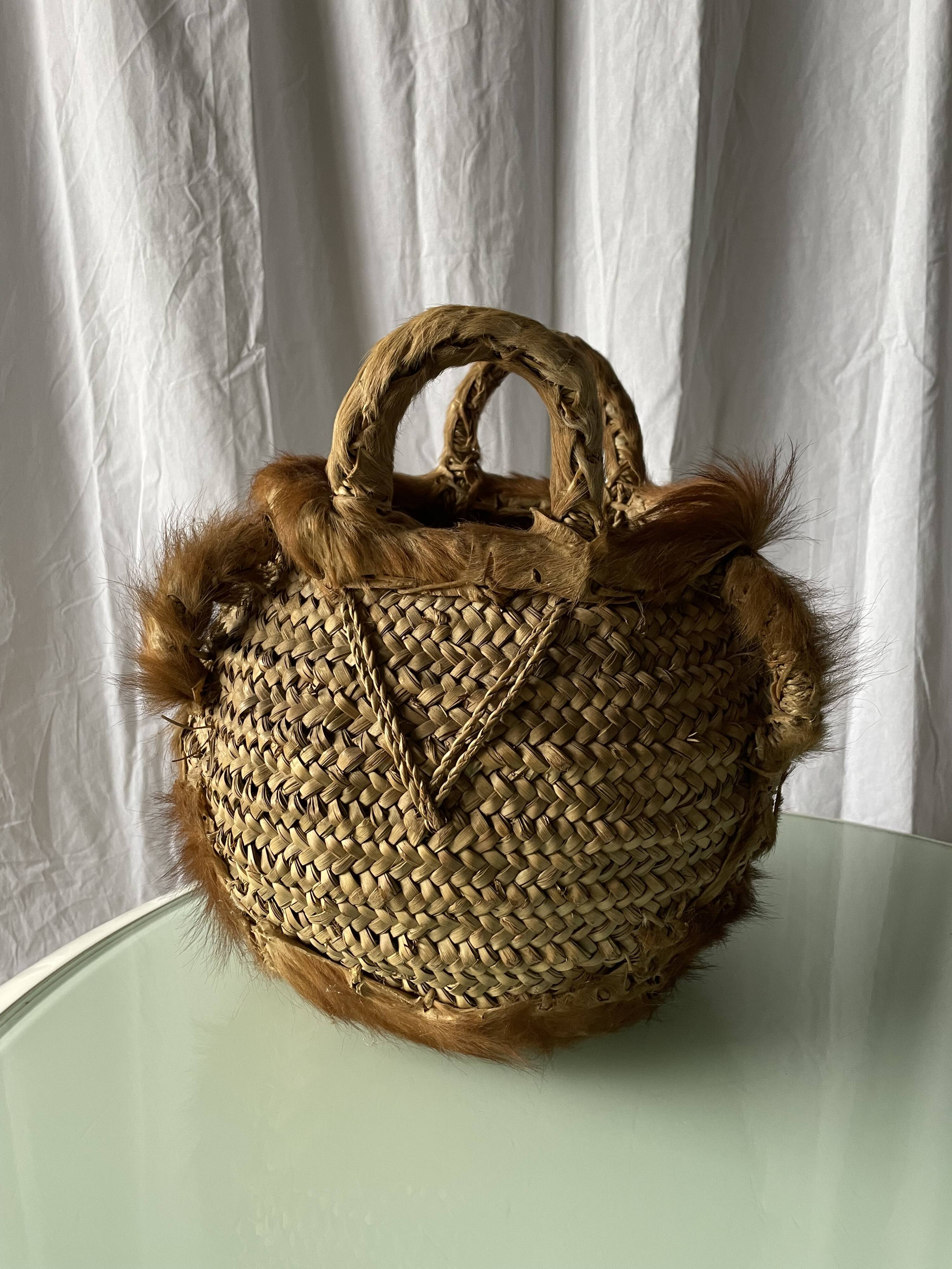 Handwoven vintage basket with handles made from natural fibres.